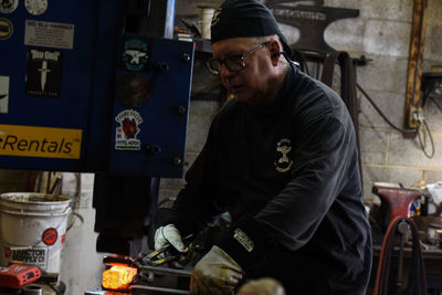 Side view of young man working in workshop