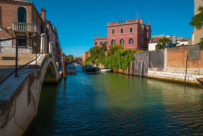 Canal amidst buildings against sky