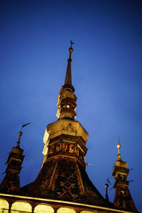 Low angle view of bell tower against blue sky
