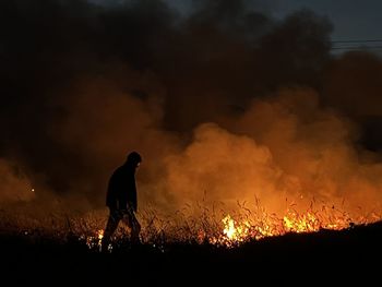 Silhouette of man with fire crackers at night