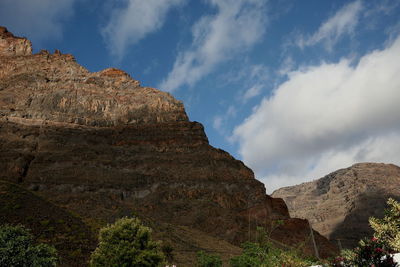 Low angle view of rocky mountains against sky