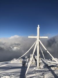 Windmill on snow covered field against sky