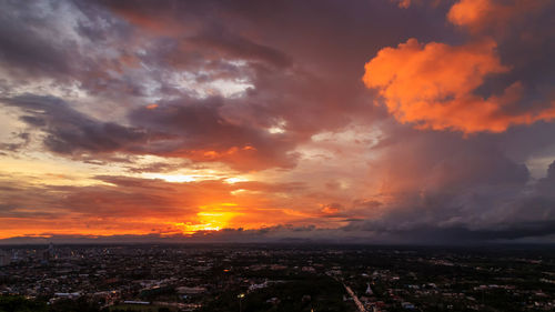 Scenic view of dramatic sky over city during sunset