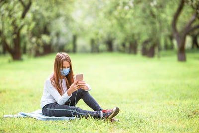 Woman sitting on grass in park