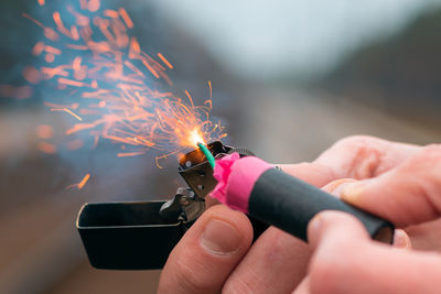 Midsection of woman holding sparkler at night