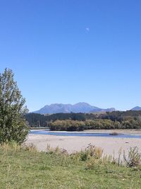 Scenic view of lake against clear blue sky