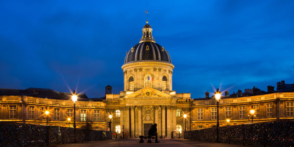 Illuminated building against clear sky at night