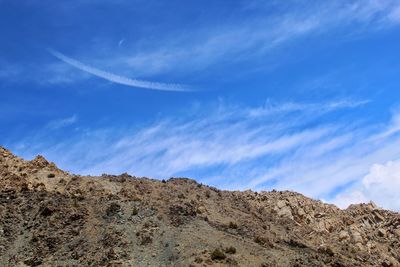 Low angle view of mountain against blue sky