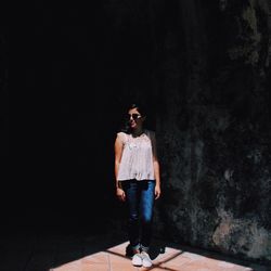 Full length of young woman standing by railing