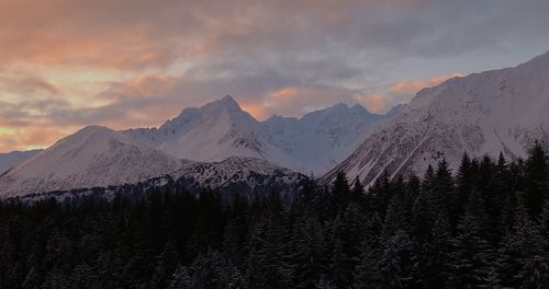 Scenic view of snowcapped mountains against sky during sunset