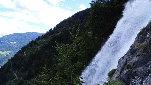 Low angle view of waterfall against sky