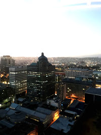 High angle view of illuminated buildings in city against clear sky