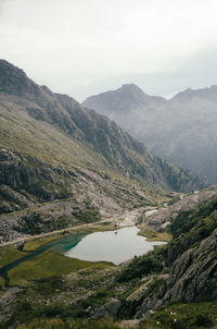 Scenic view of river amidst mountains against sky