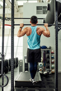 Rear view of man exercising in gym