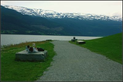 People on lake against sky