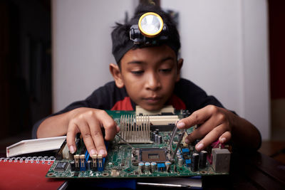 Portrait of boy playing with eyeglasses on table