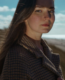 Close-up portrait of young woman against sea