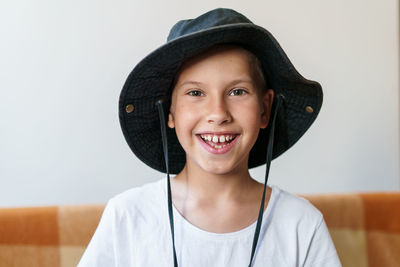Portrait of charming caucasian boy in white t-shirt and black panama hat