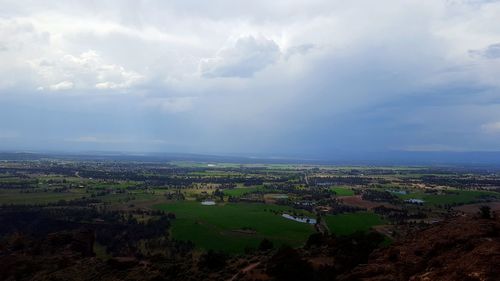 Aerial view of field against cloudy sky