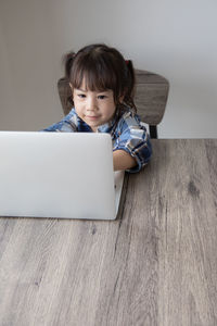 Portrait of girl using mobile phone at home