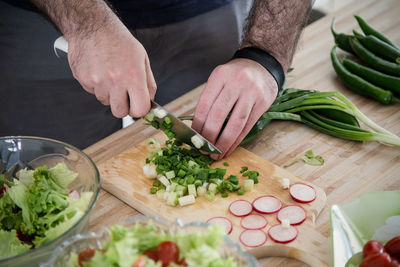 Midsection of man preparing food on cutting board
