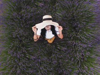 High angle view of woman wearing hat standing at lavender field