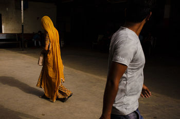 REAR VIEW OF MAN AND WOMAN ON STREET AT TEMPLE