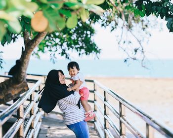 Smiling woman with daughter at beach