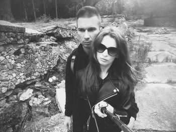 Portrait of young couple standing on footpath