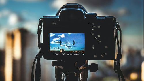 Close-up of camera photographing sky