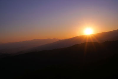 Scenic view of silhouette mountains against sky during sunset