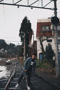 Man on railroad track against sky