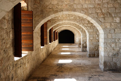 Arched castle corridor with sunlight coming through windows. 