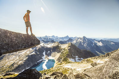 Mountain hiker looks out at view from a mountain summit.