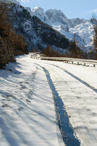 Snow covered field by mountain