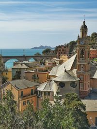 High angle view of buildings by sea against sky