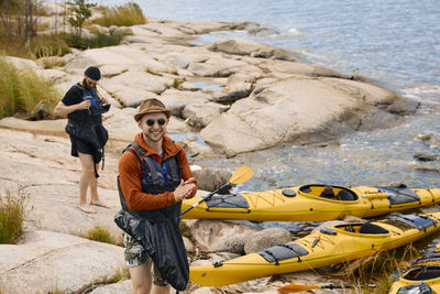 High angle view of men standing near kayaks on coast