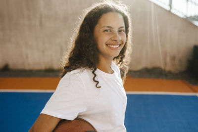 Portrait of happy pre-adolescent girl at sports court