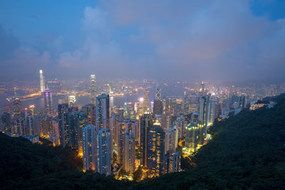 Illuminated buildings in city against sky at night