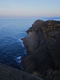 Rock formations by sea against sky