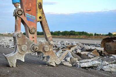 Rusty metallic structure on road against sky