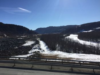 Scenic view of snowcapped mountains against blue sky