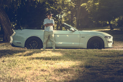 Side view of person standing by car