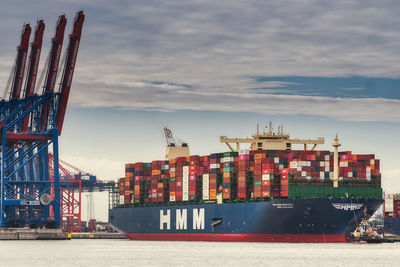 Commercial dock by sea against sky