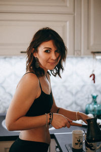 Portrait of woman preparing coffee at home