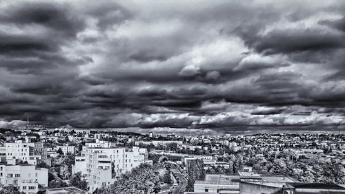 Aerial view of cityscape against storm clouds