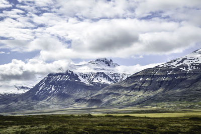 Scenic view of snowcapped mountains against cloudy sky