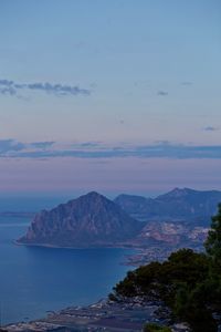 Scenic view of sea and mountains against sky at sunset