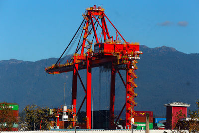 Cranes at construction site against sky