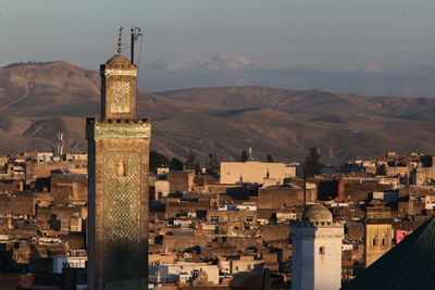Mosque against buildings and mountains